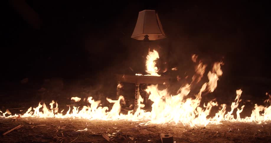 A table and a lamp burning in fire and smoke