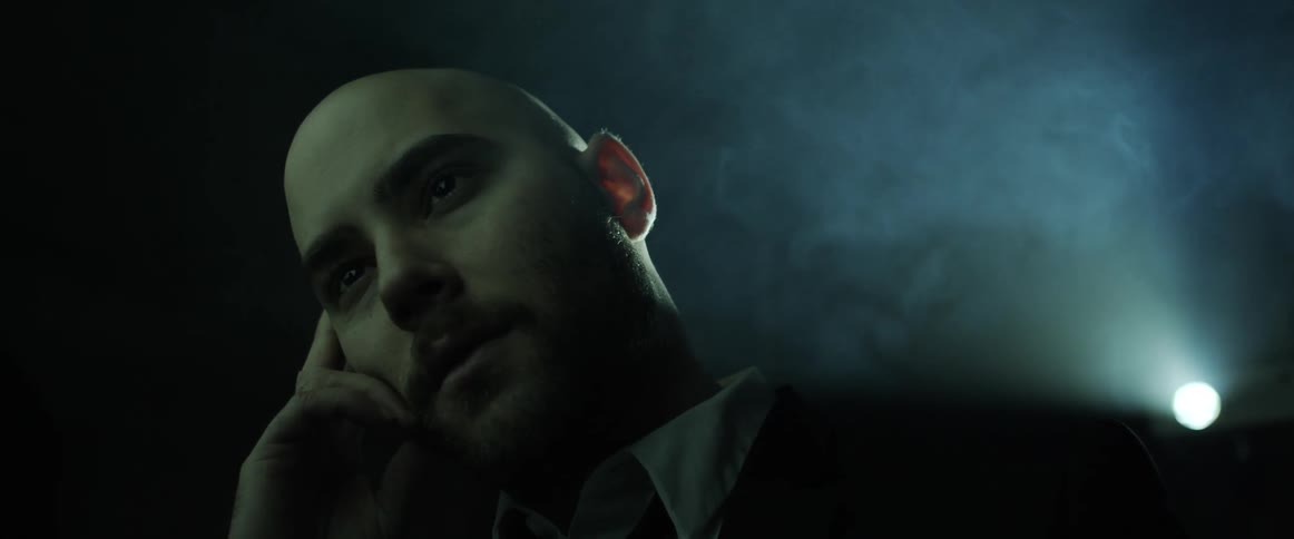 A man is sitting indoors at night