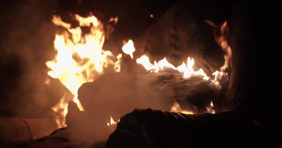 Flames burn through blackened furniture