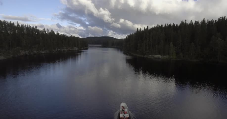 Aerial view of a boat moving down the center of a lake