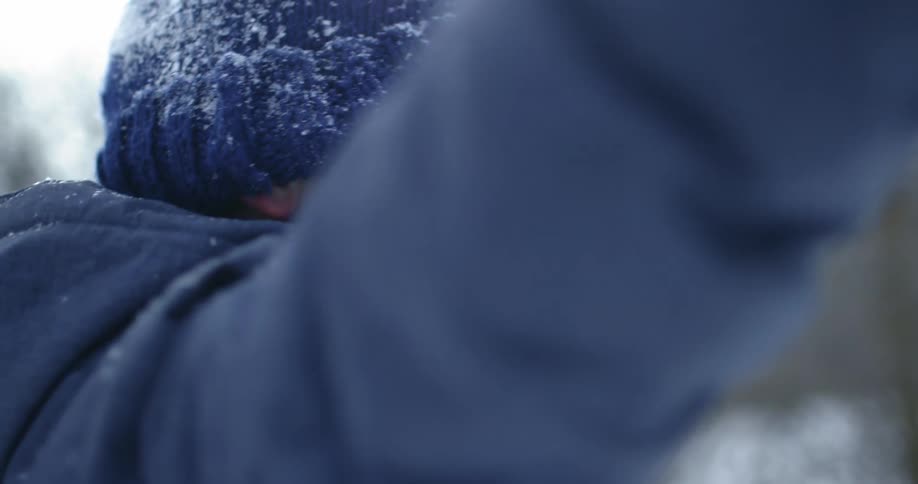 A child is playing outdoors in the snow