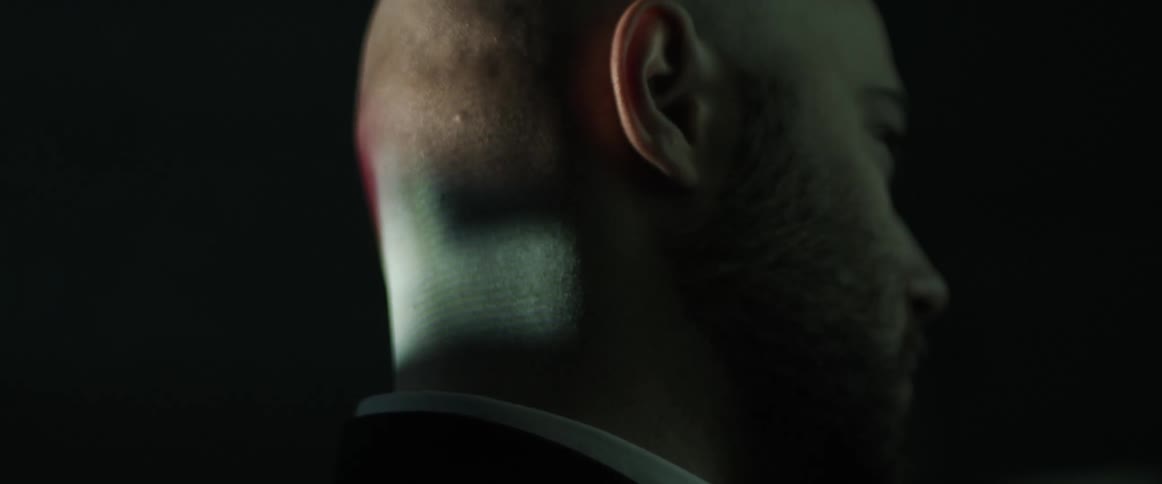 A man in a room with light projected in the back of his head