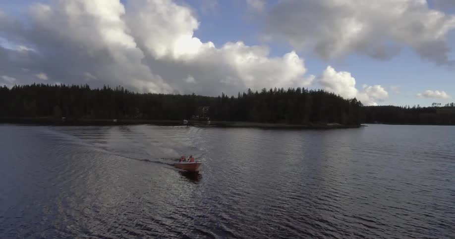People travelling across a lake in a motorboat