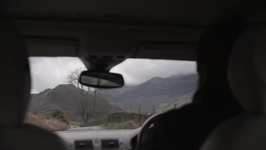 A person is driving a vehicle down a small road