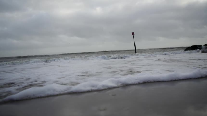 Waves rolling on the beach under stormy skies