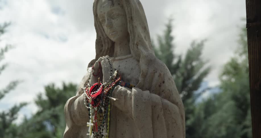 A view of a statue with necklaces on it