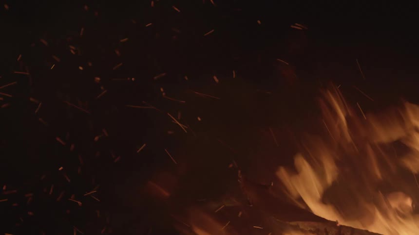 A bonfire with wood flames smoke and embers