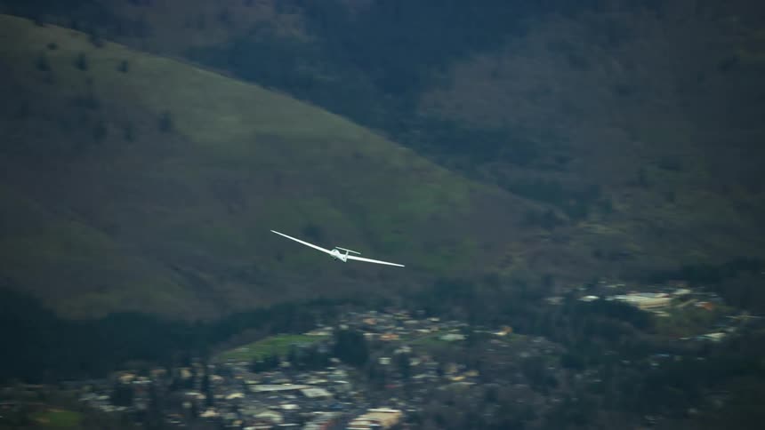 A glider airplane soars high above the Columbia River gorge in this high altitude air to air aerial shot highlighting the magic of no engine gliding flight