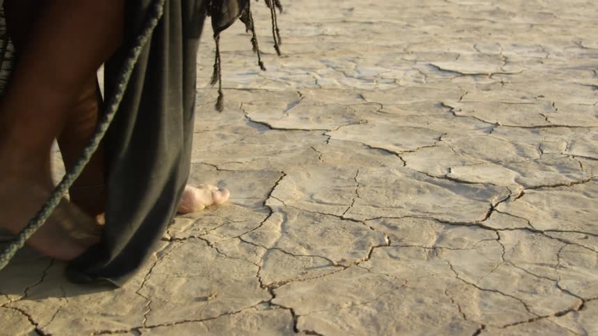 A woman walking on a dry lake bed