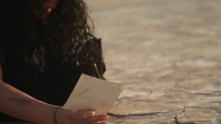 A woman lifts a photo from the ground