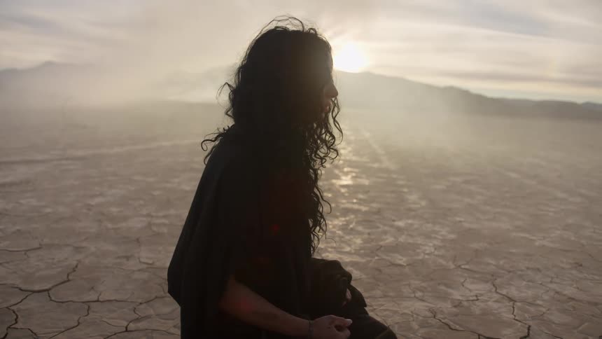 A woman standing in a dry lake bed
