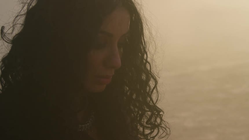 A woman standing out in a sandy area