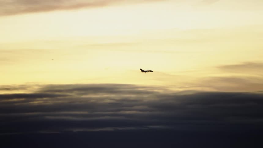 Air to air shot of a private passenger jet arriving for landing in beautiful sunset light after a long flight across the country