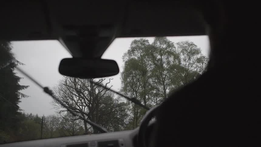 Windshield wipers swipe back and forth as a car moves