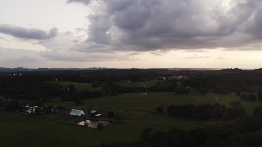 Rural community under a cloudy sky with mountains on the horizon