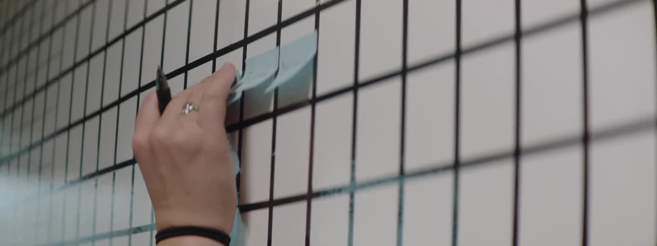 A woman in an office sticks notes on a board