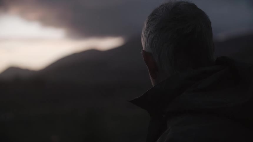 A man looks at the distant mountains