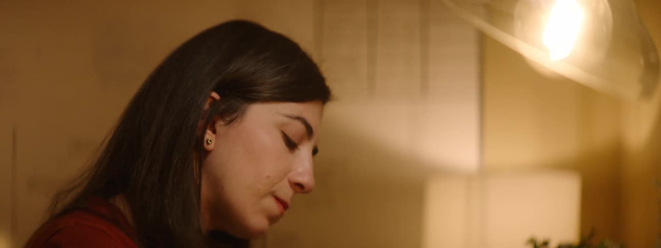 A woman pauses to think about what she is going to write in her notebook before resuming