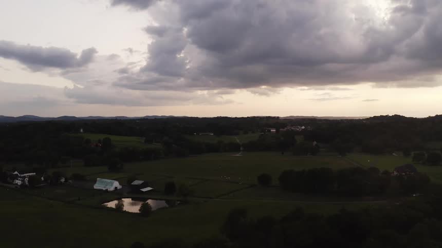 Rural community under a cloudy sky with mountains on the horizon