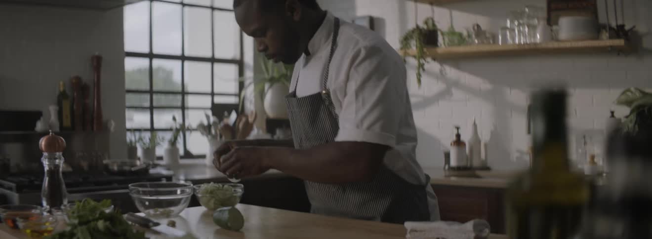A man is in a kitchen preparing a meal