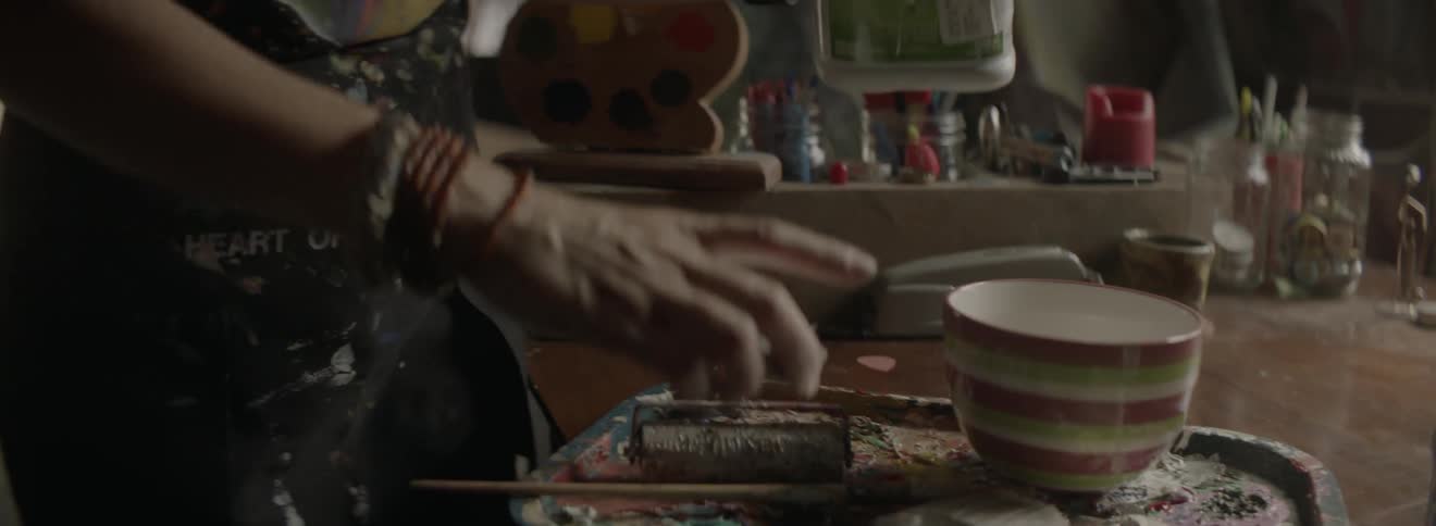 A person pours some paint into a cup
