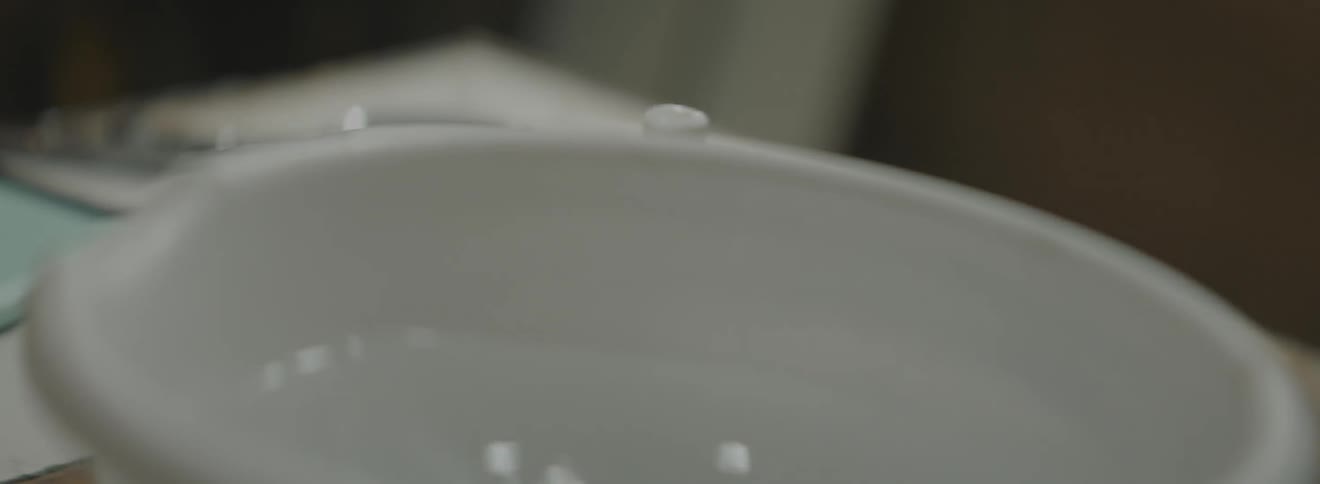 A person drops hot metal into a bowl of water