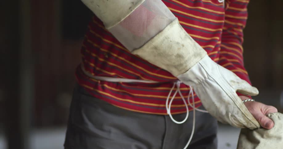 A person is wearing a gloves and standing indoors