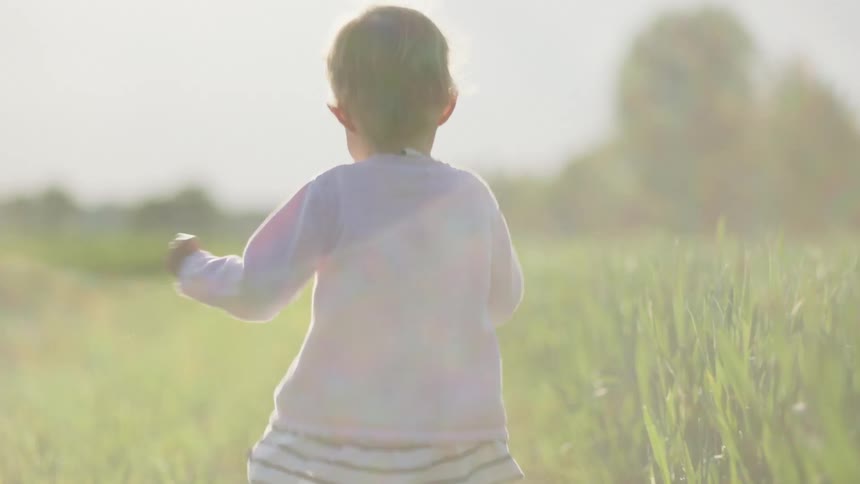 A child is running on the green field