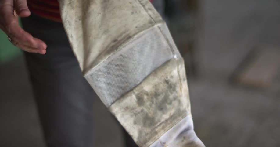 A person standing and holding a glove
