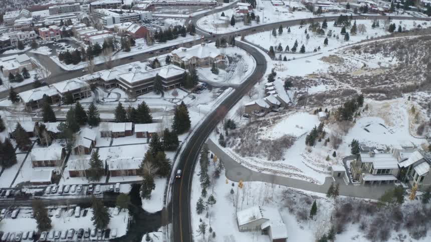 Aerial view of houses and streets in a small town covered in white snow at winter