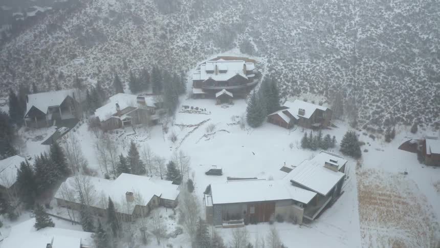 A town with houses a road and trees covered in snow
