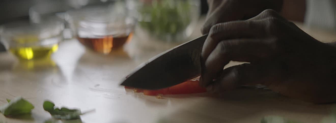 A person is dicing a tomato