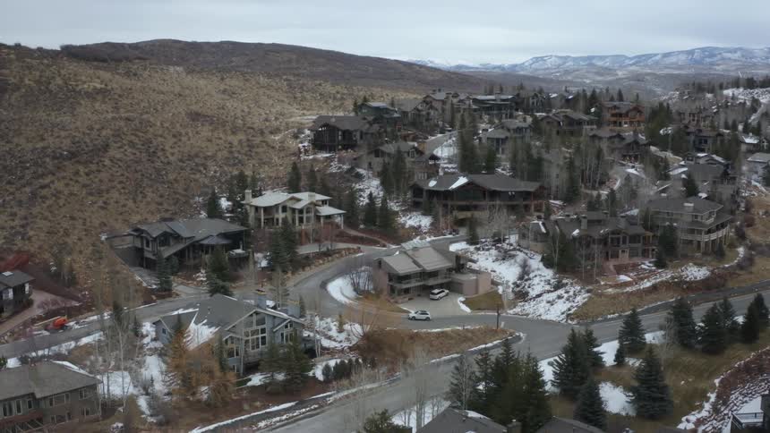 A single vehicle drives in the town on the mountain