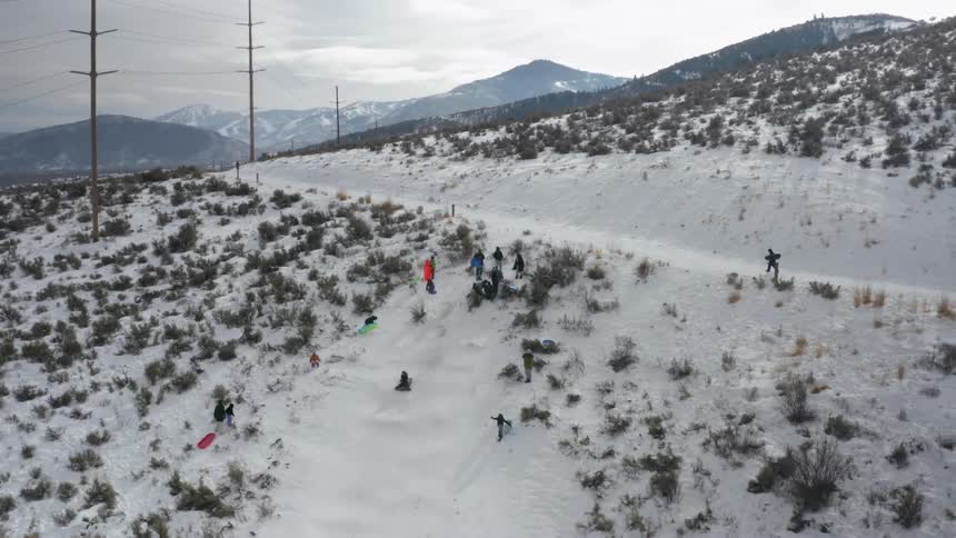 A group of people sledding down a hill