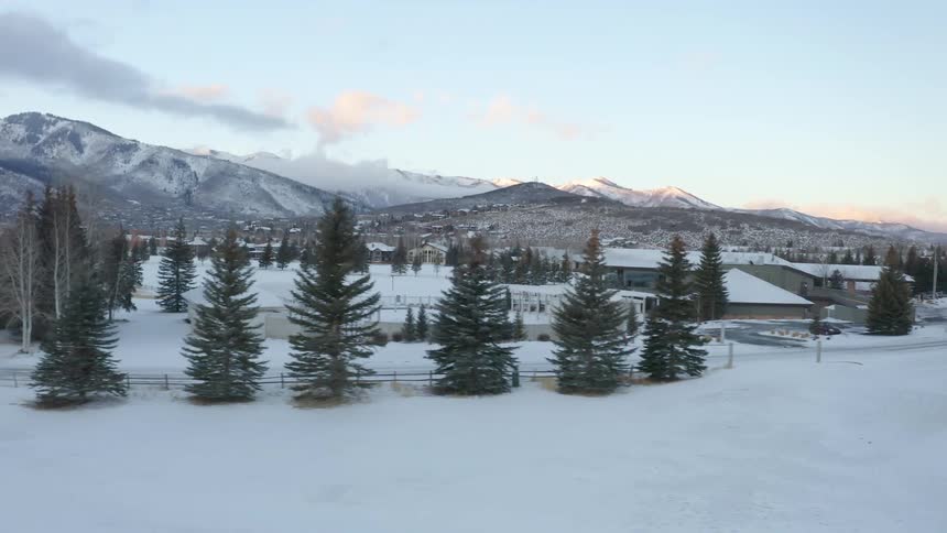 Snow covered buildings in a farm near the mountains at morning
