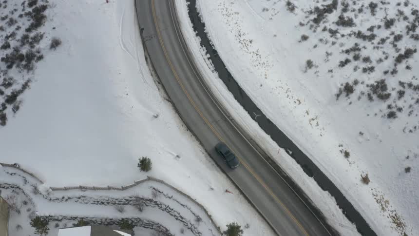 Car traveling on a road with snow covered surroundings