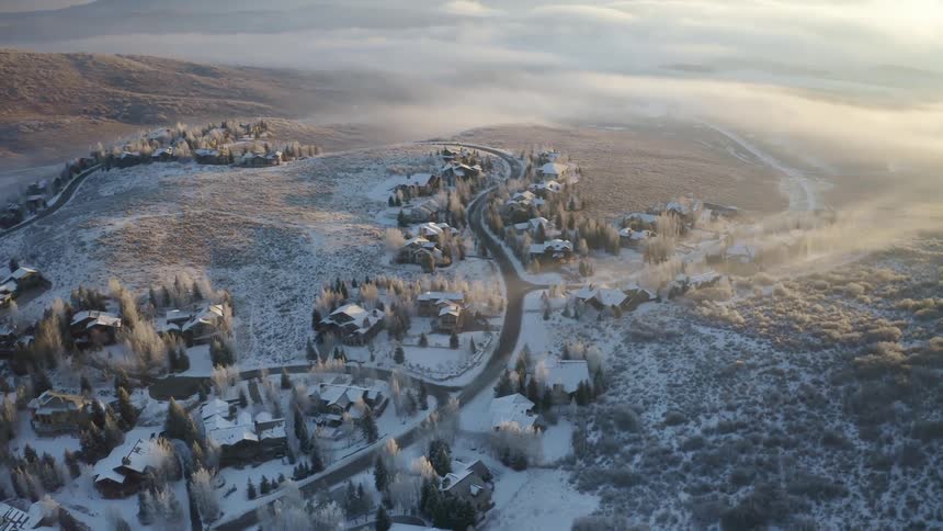 A town with houses roads and trees covered in snow