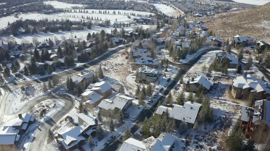 Aerial view of houses on a small town in the hills covered in white snow at winter