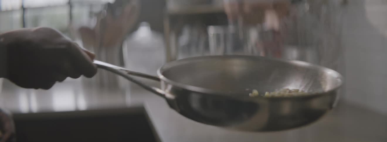 A chef flips food around in a hot pan