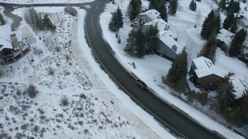 An aerial view of a car driving on a road