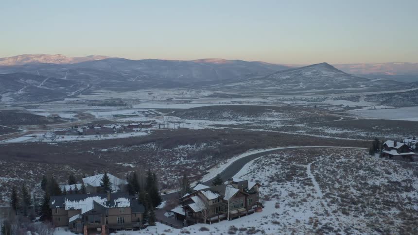Snow covered rural community with mountains on the horizon
