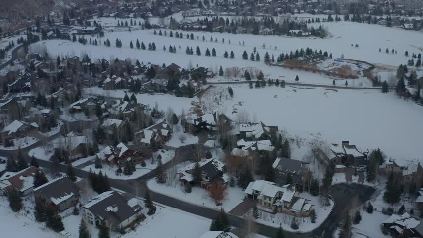 A town with houses roads and trees covered in snow