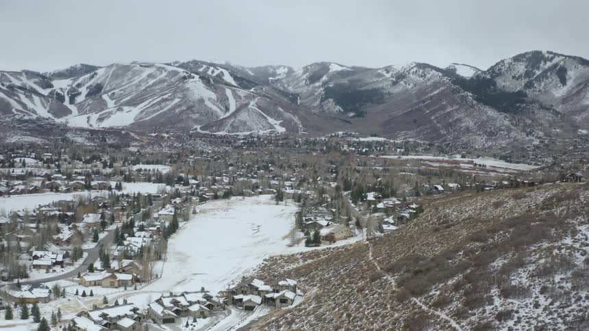 Snow covered community with mountains in the distance