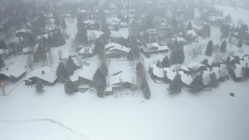 Aerial view of houses in a small town covered in white snow at winter