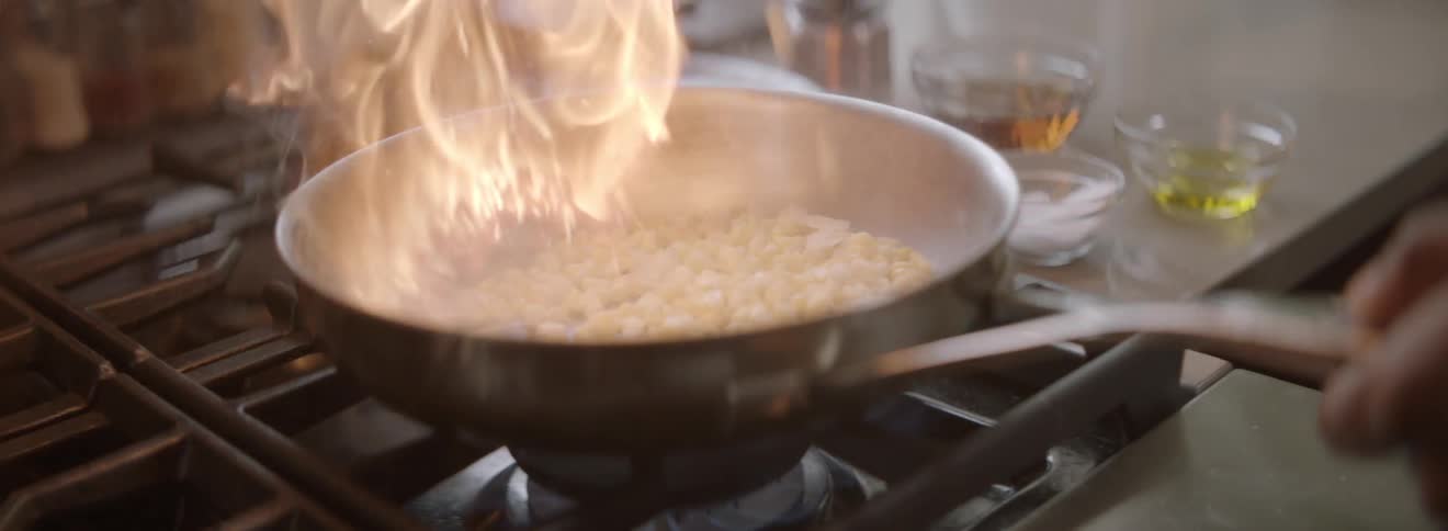 Diced onion is put into a pan and the pan flames