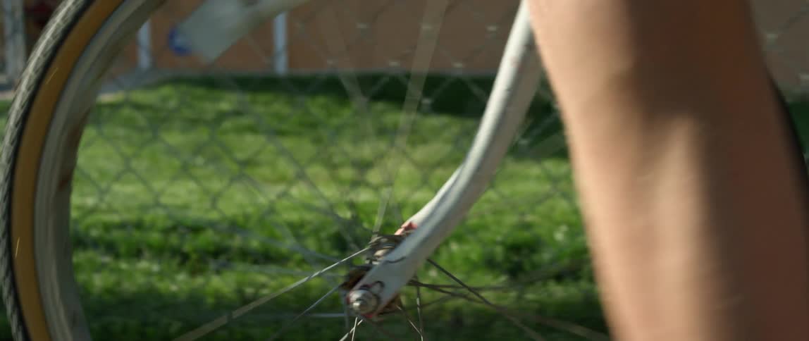 A man is walking with a bicycle outdoors in spring