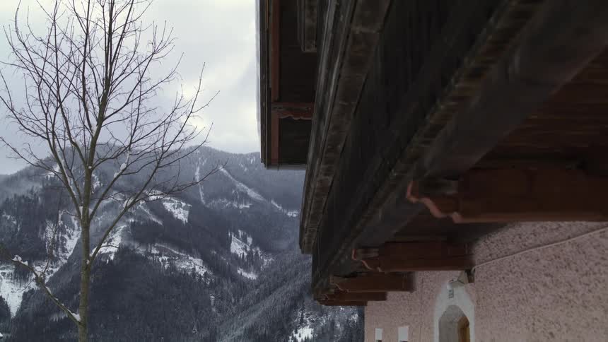 The facade of a building located on a snowy mountain range on a cloudy winter day