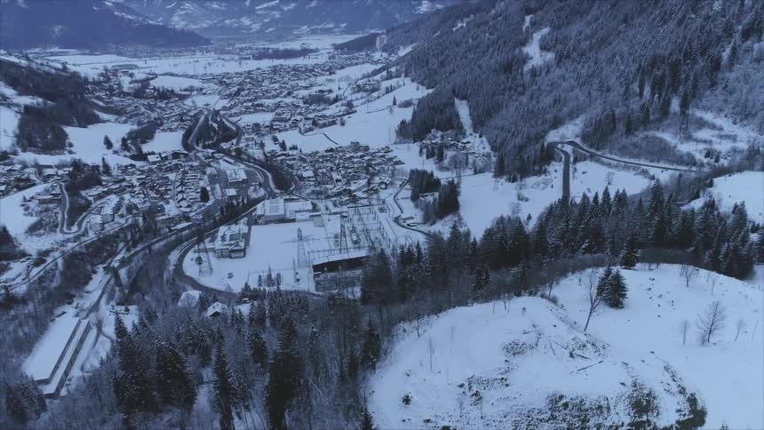 An aerial view of a city near some snowy mountains