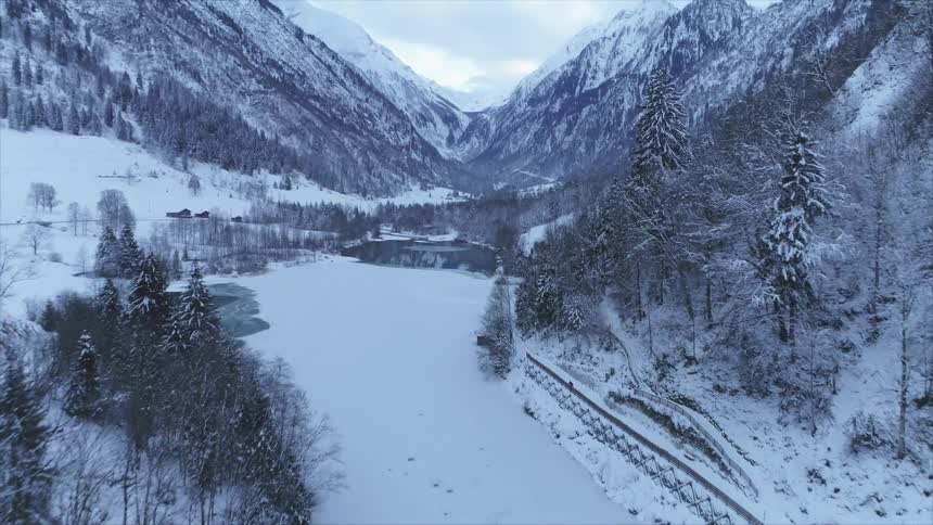 An aerial view of a snowy mountain landscape in the wilderness