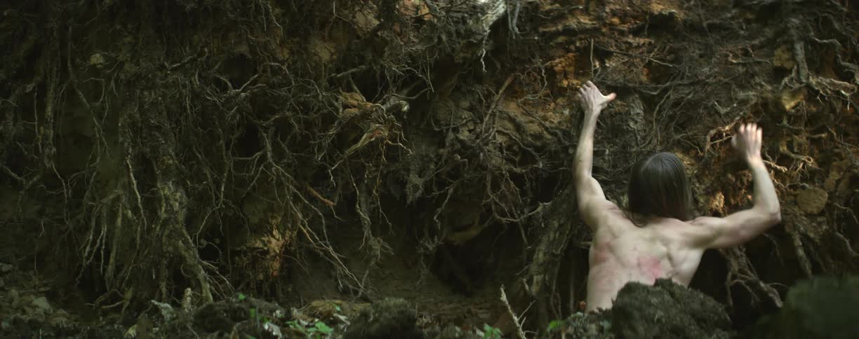 A man climbs up the side of a cliff